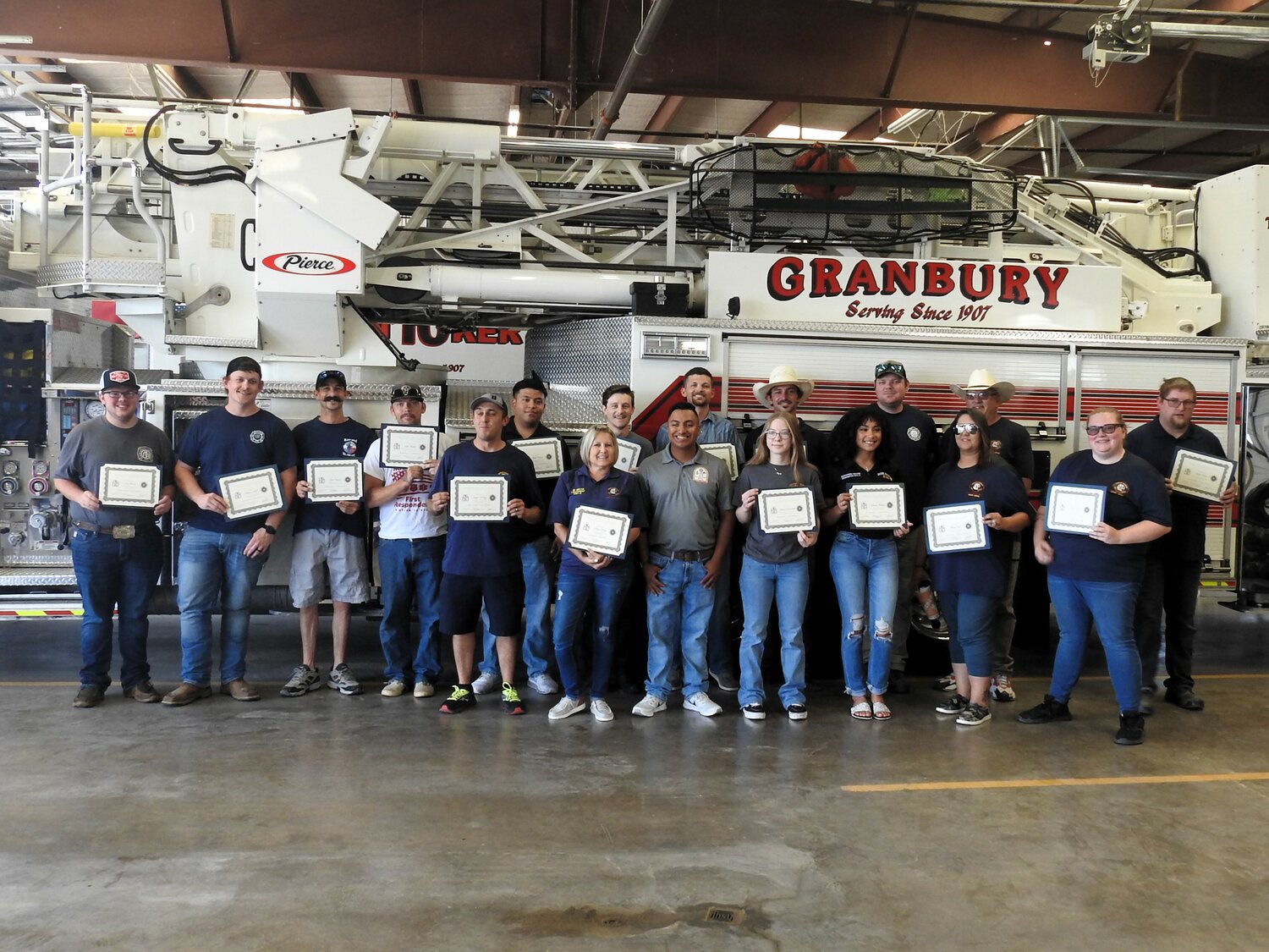 Training Lieutenant Diego Guerrero, front row center, in gray shirt, smiles proudly while standing among the Granbury Volunteer Fire Department Fire Academy’s newest graduates. Seventeen new volunteer firefighters graduated from the Academy on June 3. COURTESY OF GVFD