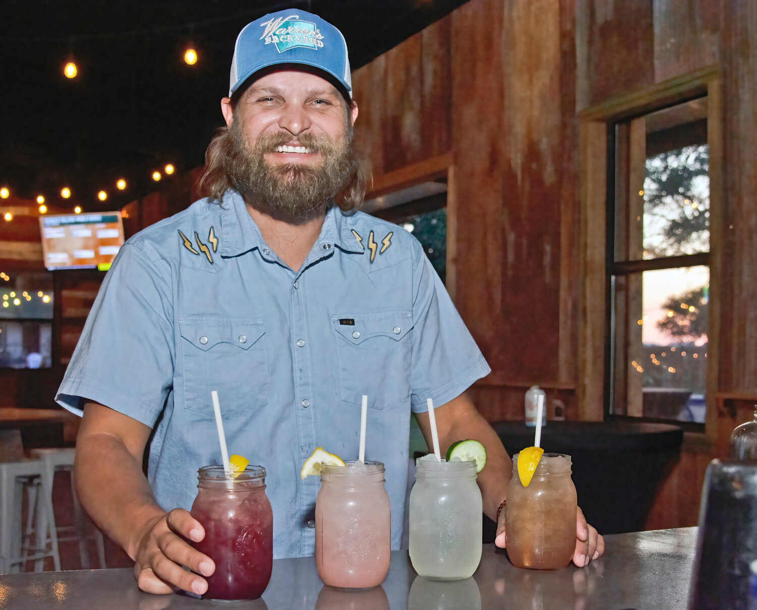 SERVICE WITH A SMILE: Tolar High School graduate Brett Berry, new owner of the revamped Warren's Backyard on Weatherford Highway, prepares to serve up some cool drinks to patrons on a recent weekend.