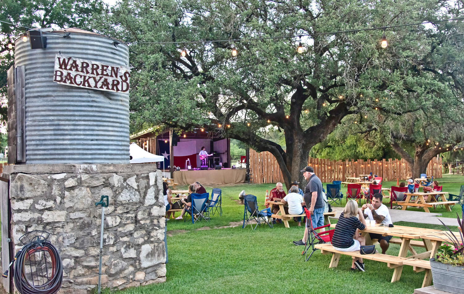 A PLACE TO RELAX: The new Warren's Backyard offers outdoor seating under lighted oak trees and a stage for live band performances.