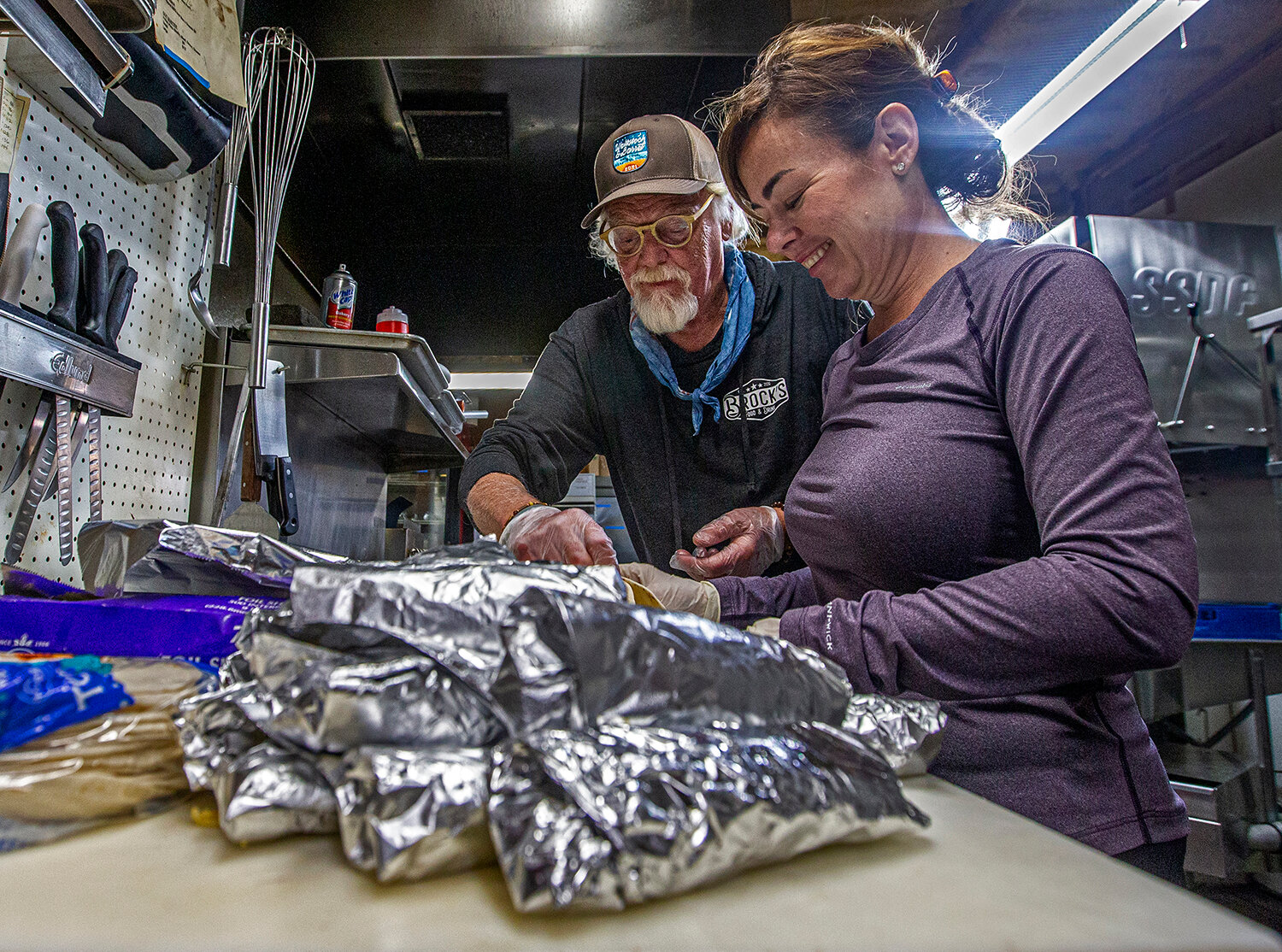 James Brock, owner of Brock’s Food &amp; Drink in Acton, is giving away 200 breakfast tacos every day through the summer for anyone — “No questions asked,” Brock said. Local real estate agent Kami Kemp helps Brock prepare the food before taking it out to the drive-through station in front of the tavern Monday, May 24, 2021.