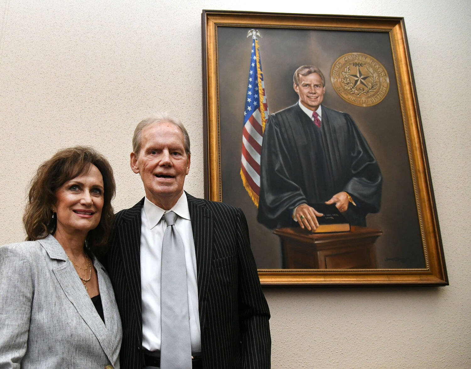 Former Hood County District Judge Ralph Walton, right, poses with his wife, Patsy Walton, in front of a portrait painted by local artist James Spurlock.
