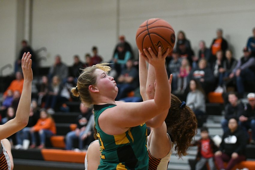 Milan's Cady Pauley drives to the basket and takes a shot through contact against Macon.