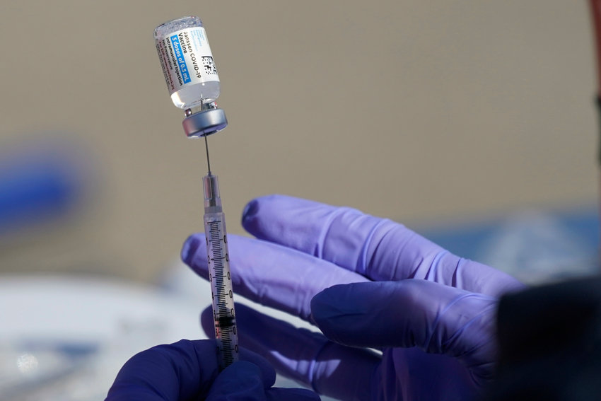 A nurse fills a syringe with vaccine at a mass vaccination site in Kansas City, Mo., Friday, March 19, 2021. (AP Photo/Orlin Wagner)
