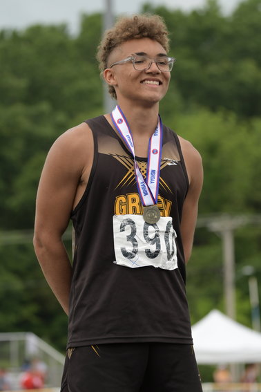 Green City's Asher Buggs-Tipton stands on the podium after winning one of his four state title this past spring during the 2021 MSHSAA State Track Championships.