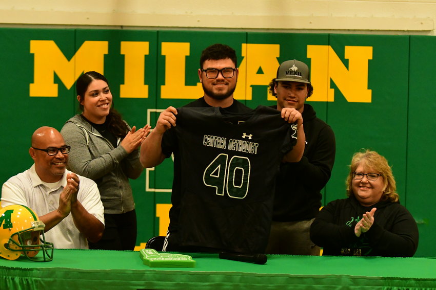 Milan's Deric Doporto holds up a Central Methodist jersey after announcing his commitment to play football and track at the university.