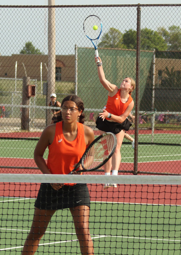 Kirksville junior Lauren Xander serves while Katlynn DeLeon waits for play to begin in a doubles match.&nbsp;