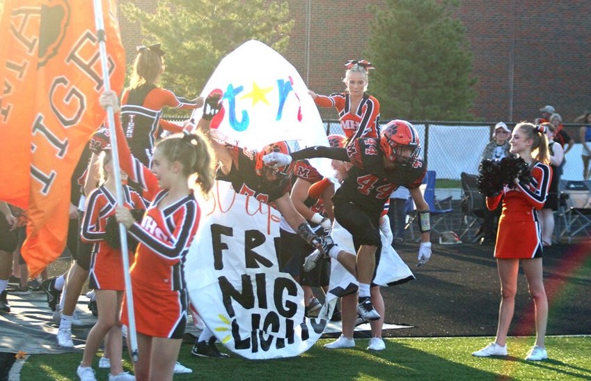 Macon football players run through a banner prior to the season opener Friday night against Kirksville at Hugh Dunn Field. Macon pulled away late to beat Kirksville by a score of 27-14.&nbsp;