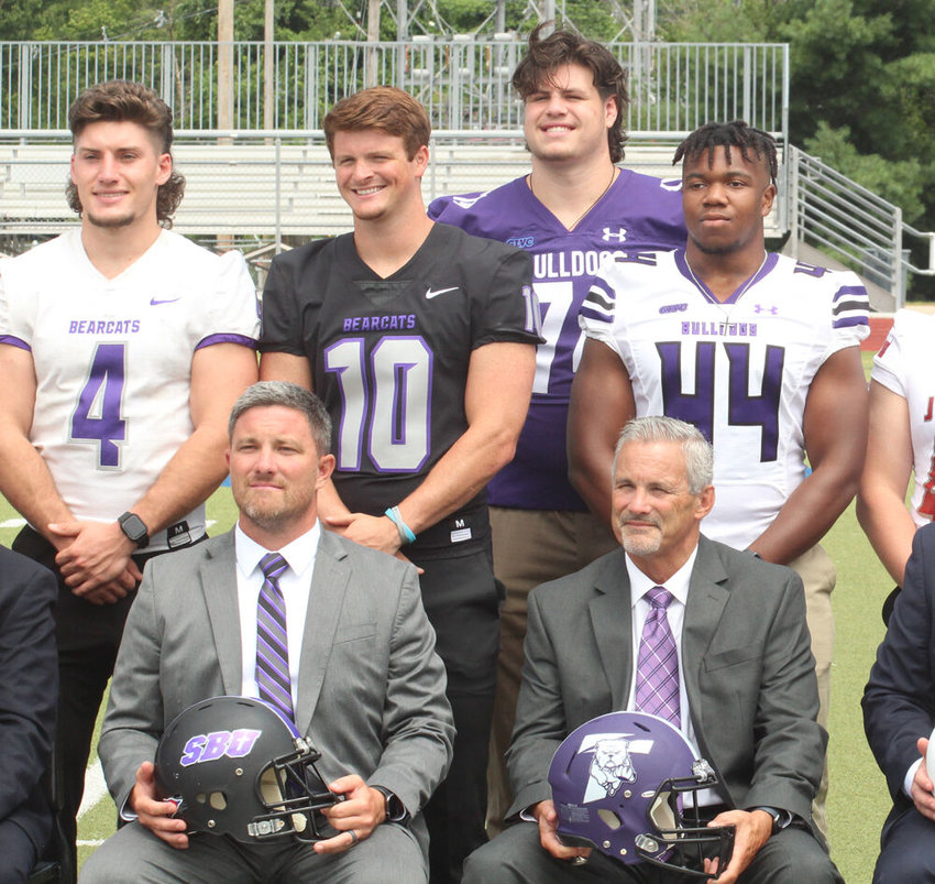 Truman state head football coach Gregg Nesbitt (seated right) and players Justin Watson and Ulysses Ross pose for photos during the GLVC Football Kickoff event on July 29 at KcKendree University in Lebanon, Illinois.&nbsp;