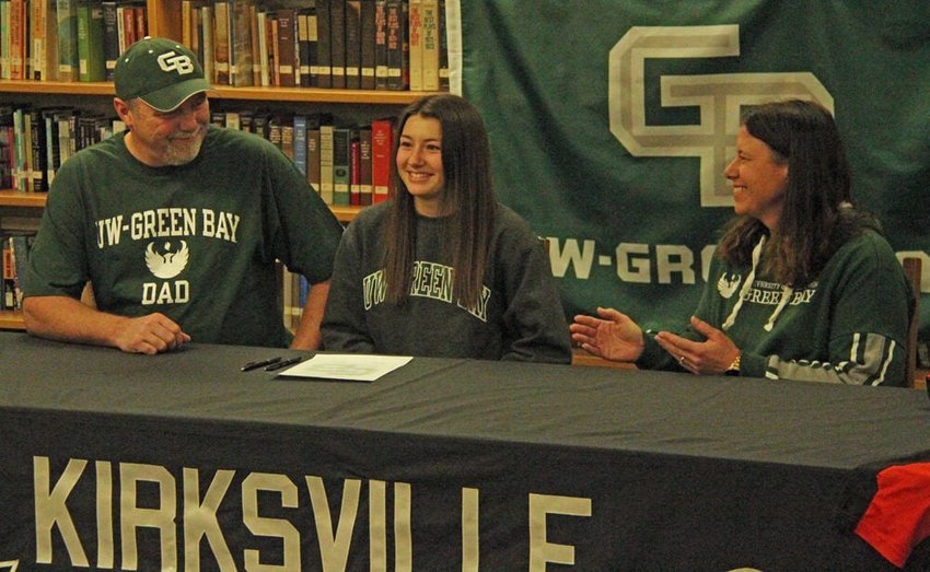 Kirksville senior Jordan Meng (center) smiles after signing to play softball at the University of Wisconsin Green Bay. Sitting with Meng are her parents Jeff and Angie Maggart.&nbsp;