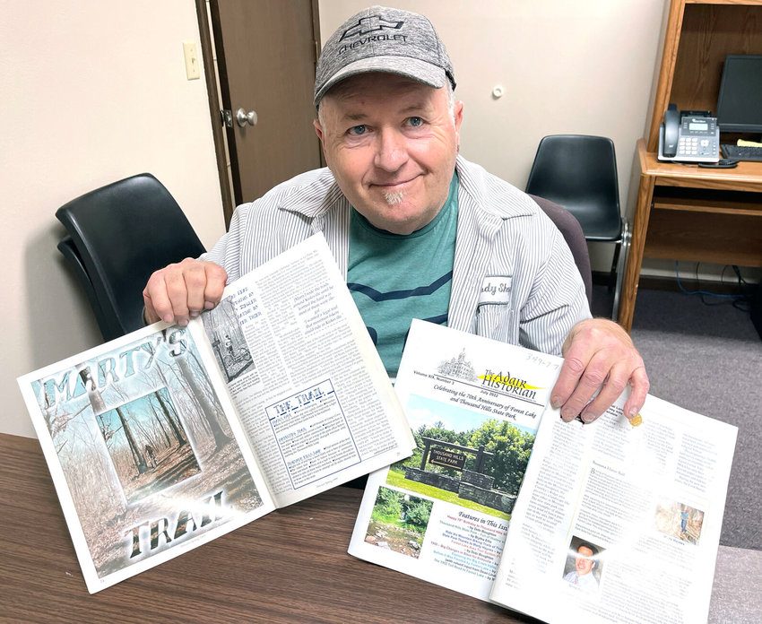 Marty Haynes holds the magazines that have written about his efforts to build and maintain a mountain biking trail in Thousand Hills State Park.&nbsp;