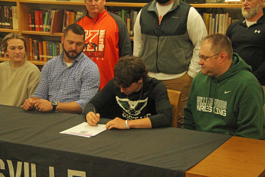 Kirksville junior Lane Patterson signs his letter to attend William Woods College as a member of the wrestling team during a ceremony at the Kirksville High School library on April 18.&nbsp;