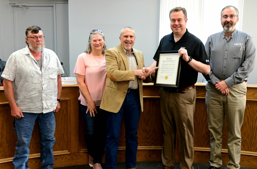 Larry Bradshaw receives a resolution from Kirksville Mayor Zac Burden at the May city council meeting.&nbsp;