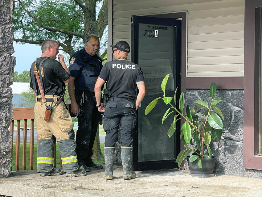 Fire investigators examine the door, which had been pried open, at the office at 701 E. LaHarpe Street.&nbsp;