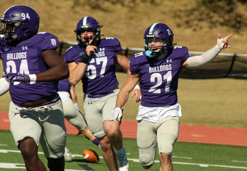 Truman defensive back Ben Thomas (21) and teammates Jack Weltha (57) and Thomas Spaulding (94) celebrate Thomas' interception on the first play of the game against William Jewell on Oct. 21.&nbsp;