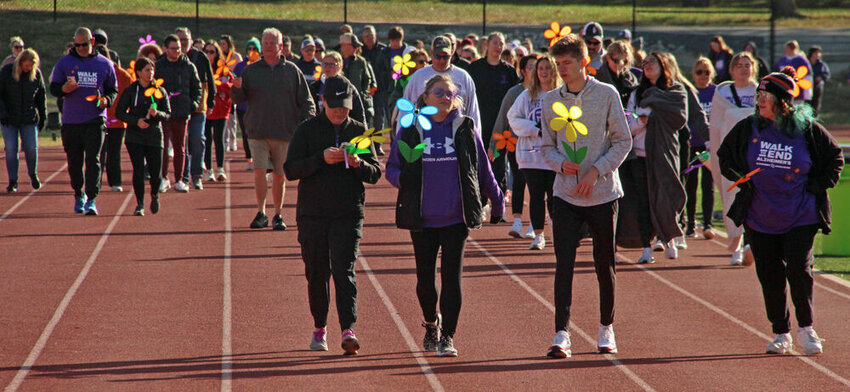 Participants in the Walk to End Alzheimer's walk down the back straightaway of the track during the event on Oct. 22.&nbsp;