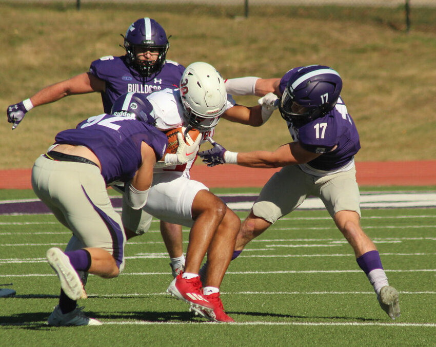 Truman defensive lineman Garrett Linn (92) and defensive back Peyton Carr (17) bring down a William Jewell ballcarrier in the game on Oct. 21.