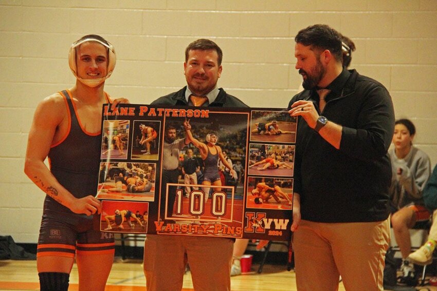 Kirksville senior Lane Patterson celebrates his 100th career pin with head coach James Alter (right) and assistant coach Justin VanHoose on Feb. 1.&nbsp;