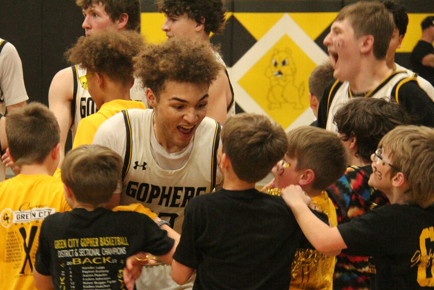 Green City senior Asher Buggs-Tipton celebrates with a group of young fans after the Gophers' quarterfinal win on March 2.&nbsp;