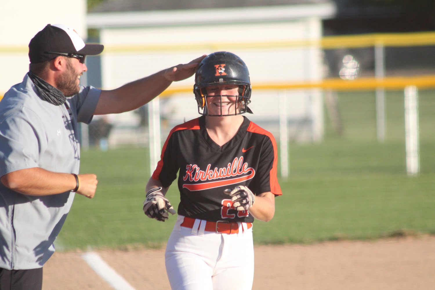Kirksville catcher Madi McCarty smiles and gets a pat on the helmet from coach Derek Allen after hitting a home run Tuesday against Hannibal.