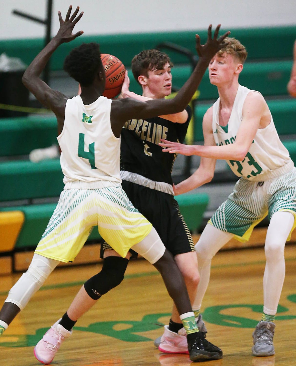 Milan's Chekh Niasse, left, and Jeremy Bennett defends Thursday evening during the 61st Milan Invitational Tournament.