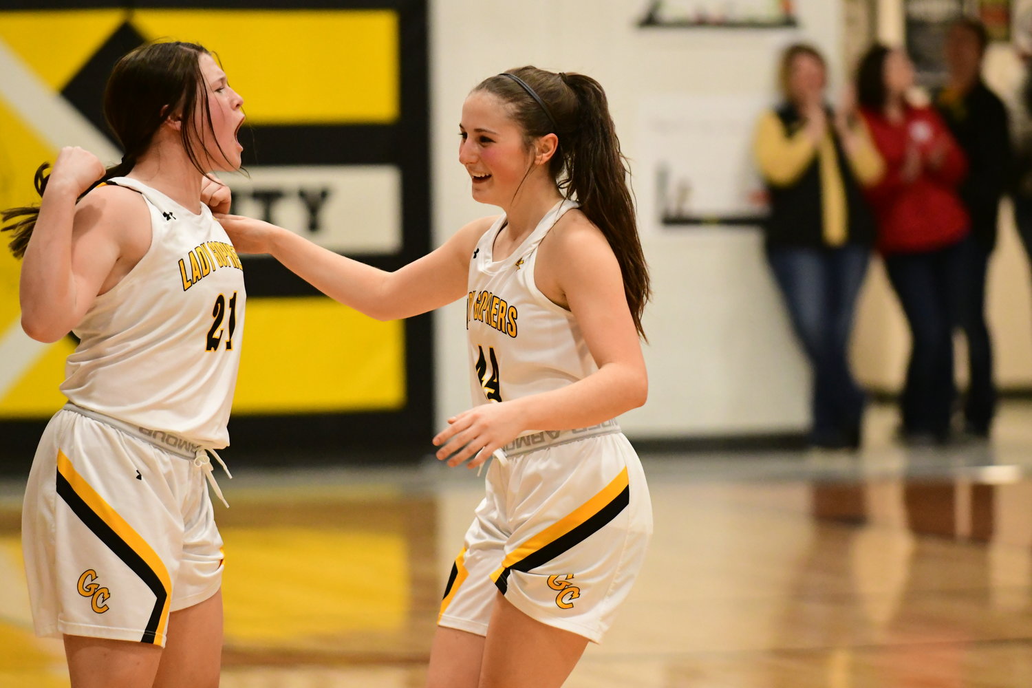 Green City's Lily Helton (left) cheers with teammate Celeste Athon during a timeout to commemorate Athon's 1,000th career point during a win against Novinger on Jan. 21, 2022.