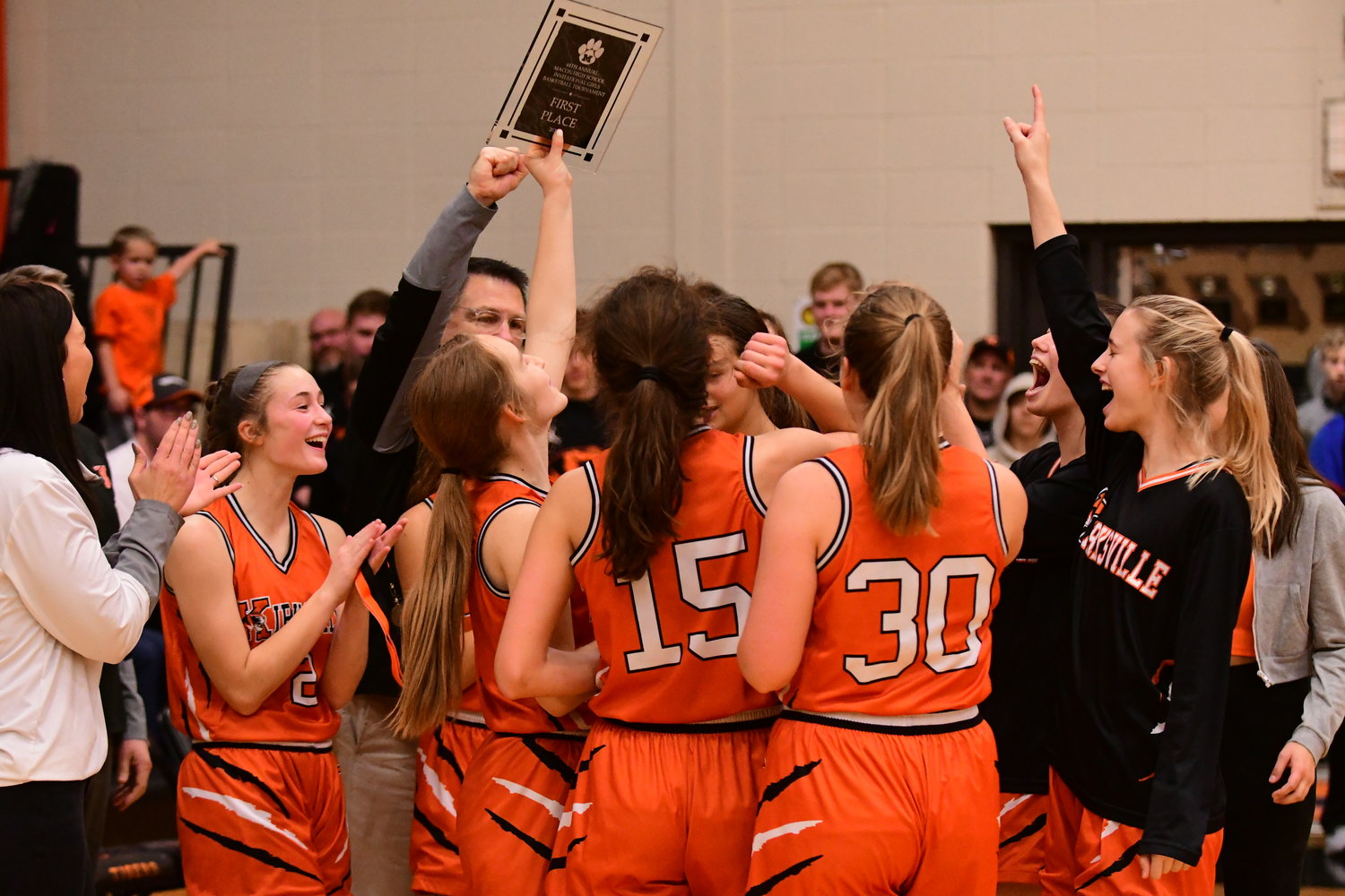 The Kirksville girls basketball team celebrates with its trophy after winning the 44th annual Macon Invitational Tournament.