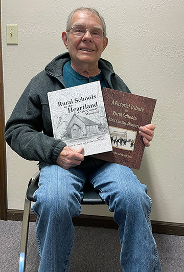 Larry Evans holds the two books he co-wrote on the history of rural schools in Adair County.