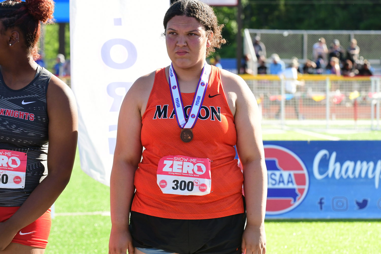 Macon's Chezney Smith stands on the podium after taking eighth in the Class 3 girls shot put.