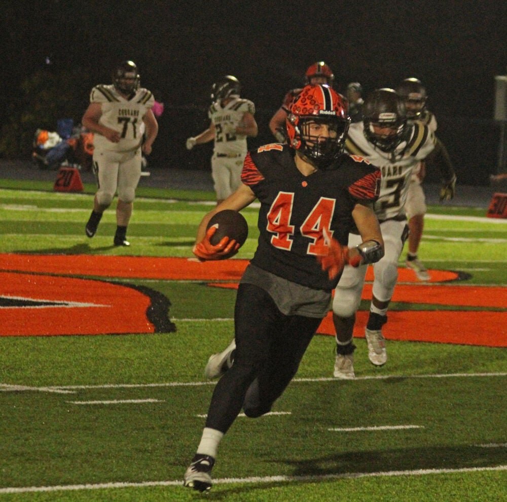 Macon senior Bryant Carpenter runs up the field after catching a pass against Highland on Sept. 23. 