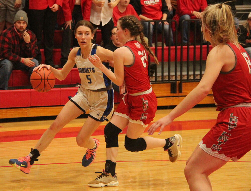 Atlanta senior Kyley Magers drives past a pair of Novinger defenders in the district semifinal game on Feb. 23.  