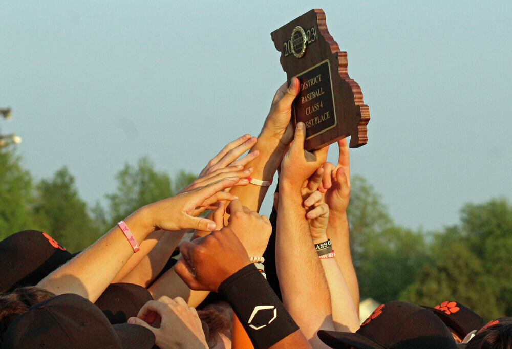 The Macon baseball team holds up their district trophy after beating Mexico in the championship game on May 18.