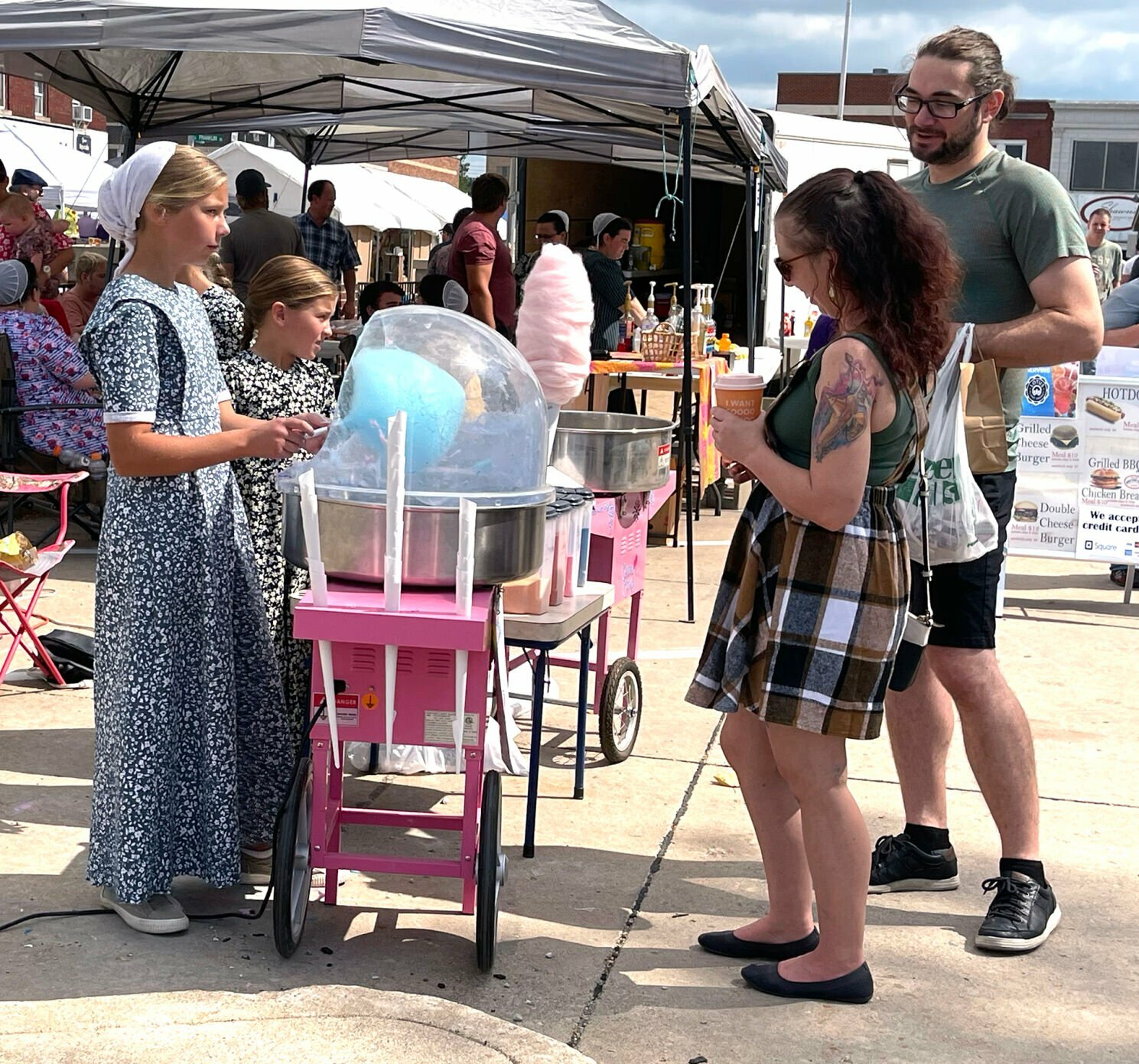 A shopper waits for her cotton candy to be made at the Red Barn Arts and Crafts Festival.