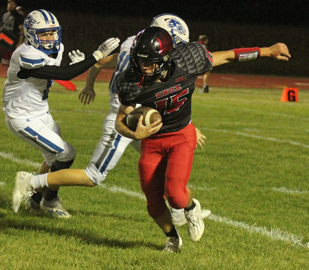 Knox County senior Reice Miller runs by a pair of defenders in the game against Paris on Sept. 29. 