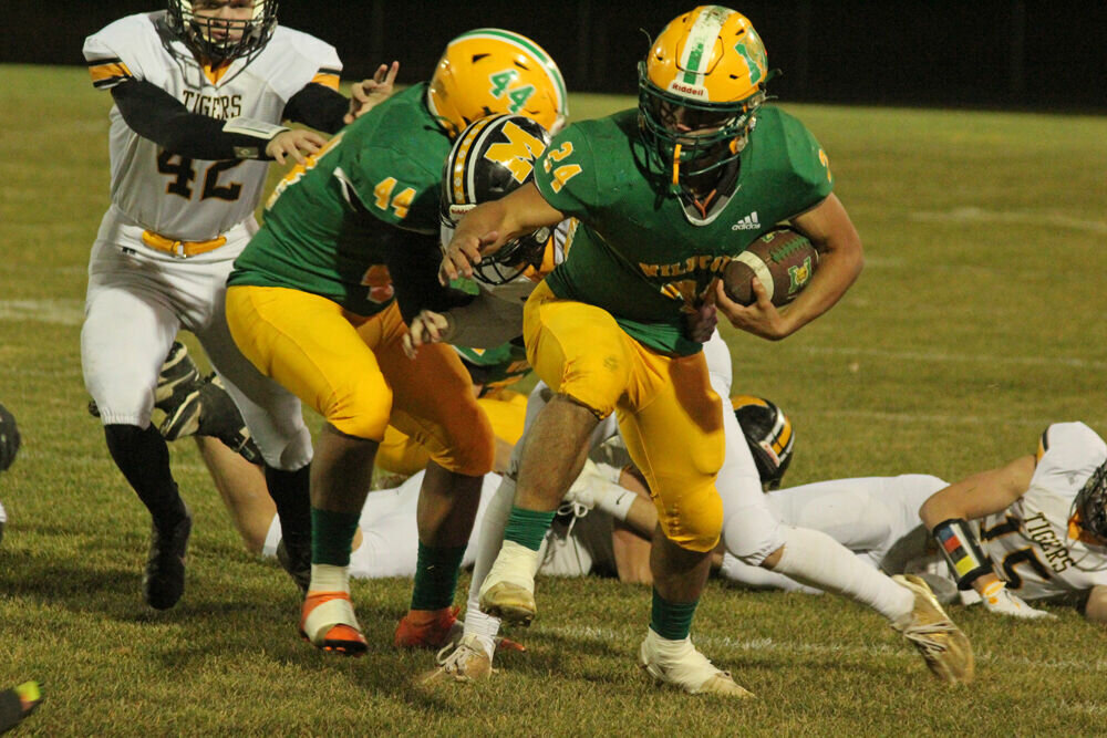 Milan senior Carlos Cotto runs through contact in the game against Marceline on Nov. 10. 