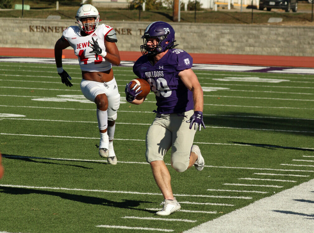 Truman running back Mason Huskey runs along the sideline in the game against William Jewell on Oct. 21. 
