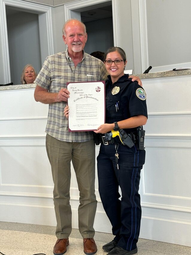 Hendrix Longfellow holds a copy of the proclamation dedicating September as Childhood Cancer Awareness Month in Long Beach.