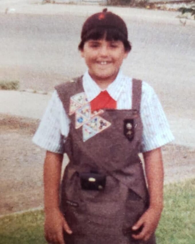 Little Melissa shows off her Brownie uniform outside her home in Alamogordo, New Mexico.