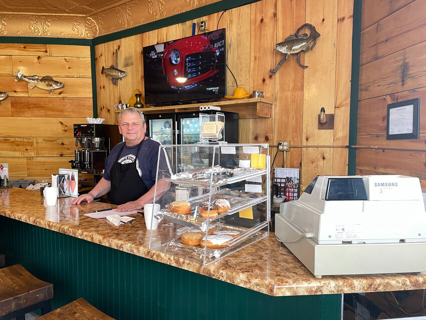 Kozy Corner Kitchen owner Bob Lass behind the counter of his newly renovated restaurant. At the top of the photo, you can see part of the historic ceiling.