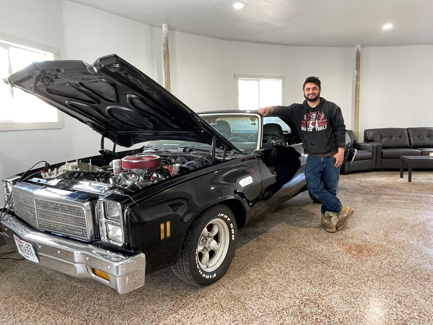 Matt Smith, owner of the new repair shop, poses beside his El Camino, on display in the waiting area.
