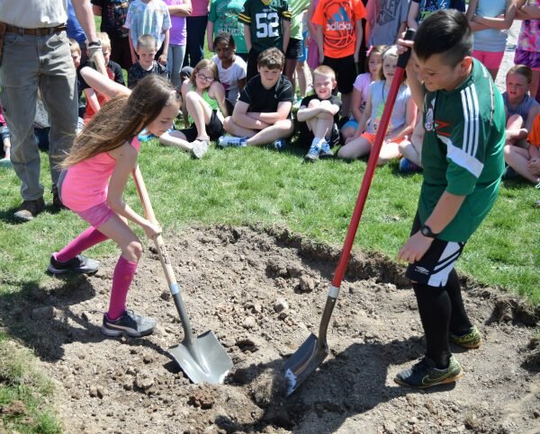 Grant Elementary students Addasyn Hollatz and Jonathan Gutierrez help dig a space to plant a tree on Friday, May 6. 