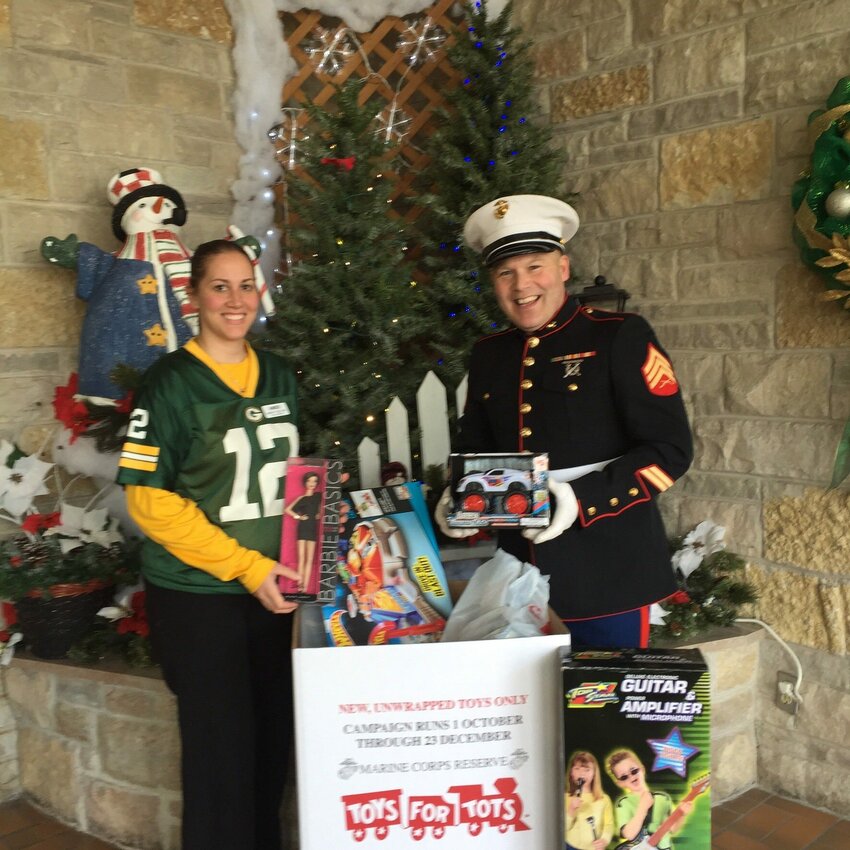 Amber Vogeltanz of Algoma Long Term Care and Matt Joski are shown with holiday gifts collected during a past Toys for Tots program in Kewaunee County. Local residents can sign up their children by phone or at the county building through Dec. 10 to receive gifts this year, with the toys handed out Dec. 17.