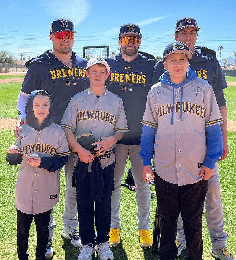 Owen Strege of Algoma, Nolen Rosenthal of Lannon and Dazian Garcia of Greenfield, front row from left, are joined on the field by Milwaukee Brewers players Luke Voit, Garrett Mitchell and Christian Yelich at the Brewers' spring training camp in Phoenix. The three boys, all of who deal with pediatric health issues, were chosen by Aurora Health Care to be guests of the team for the first weekend of spring training and throw out the first pitch of the opening game Feb. 25.