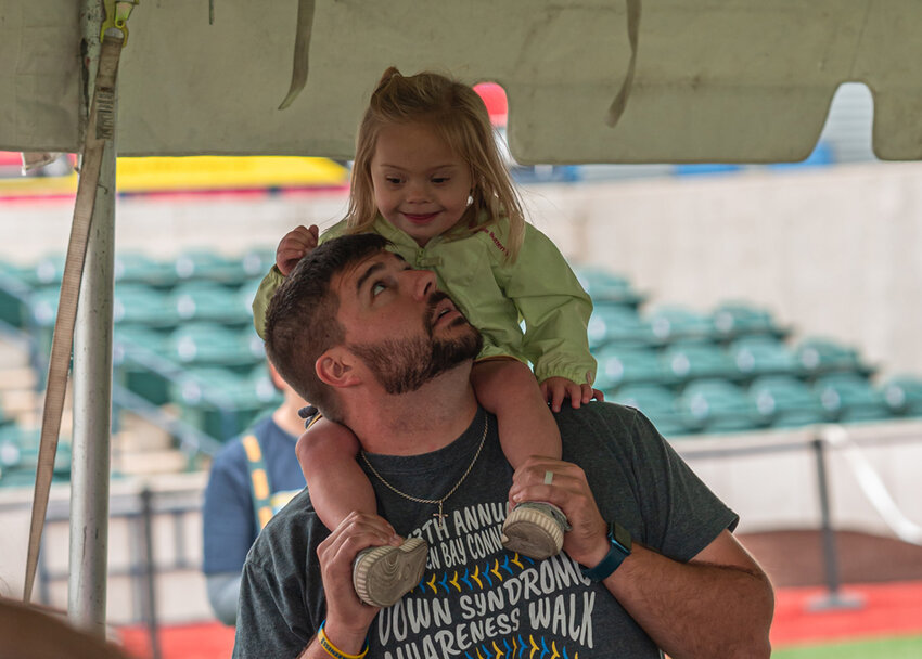 A man with his young daughter on his shoulders