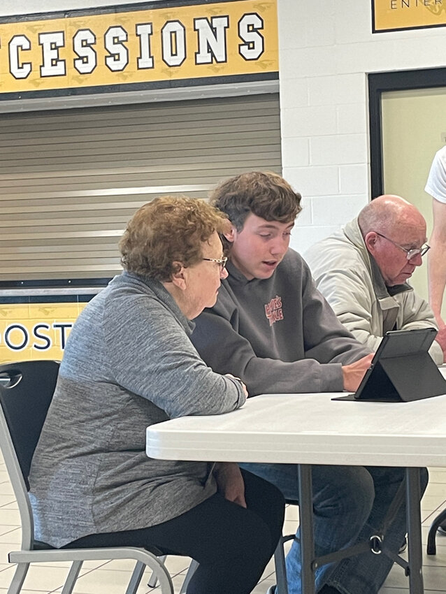 Algoma High School Junior Ethan Moore assist a community member through the Teen Teaching Technology program. Submitted photo