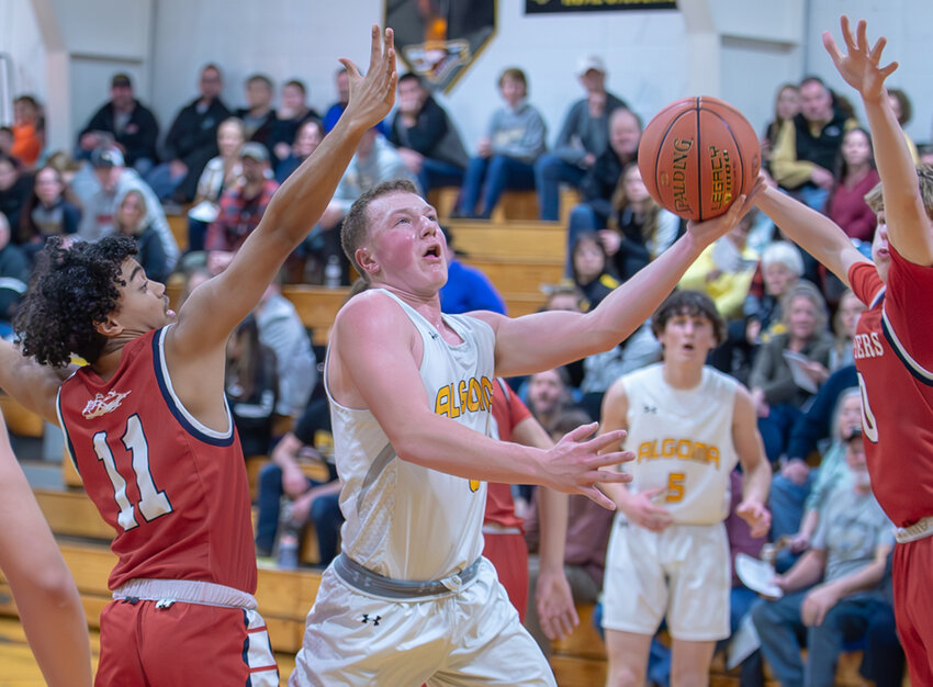 Algoma's Chase Romdenne drives through two Sturgeon Bay defenders on his way to the basket