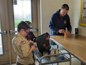 Members of Algoma’s Pack 4112 and BSA Troops 1019 and 6019 pack food received from area residents. 