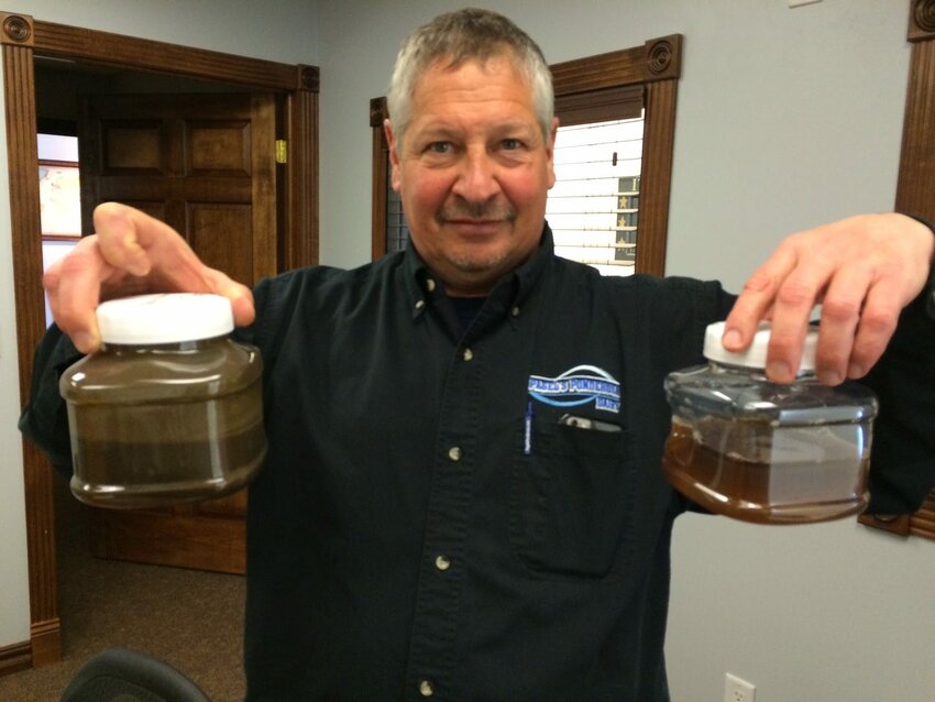 John Pagel displays liquid manure before (left) and after it has been processed to remove harmful nitrogen and phosphorus.