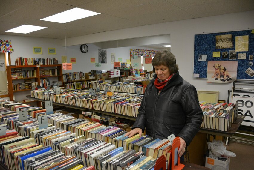 Mary Wolske, a member of the Friends of the Library, sorts some of the group's donated books.   The group is seeking a new location for its book sales that benefit the Kewaunee Public Library..