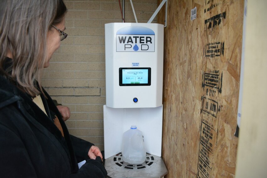 Barb Rodgers, president of the Algoma School Board, tries out the new kiosk for clean water in January.   The kiosk has since been vandalized three times and the school board is uncertain whether they can keep it operational.