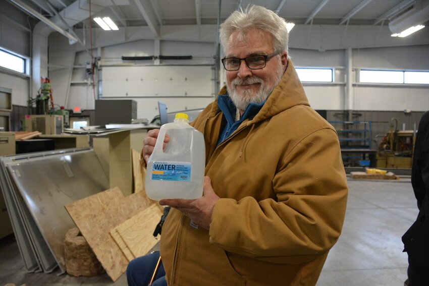 Algoma School Board member John Pabich smiles after receiving one of the first jugs of clean water provided by the school district's new kiosk in January.  The DNR and EPA have failed to provide any clean water to county residents with contaminated wells.  After the  school's water kiosk was vandalized three times in the last two months, officials said they are not sure they can keep it operational.